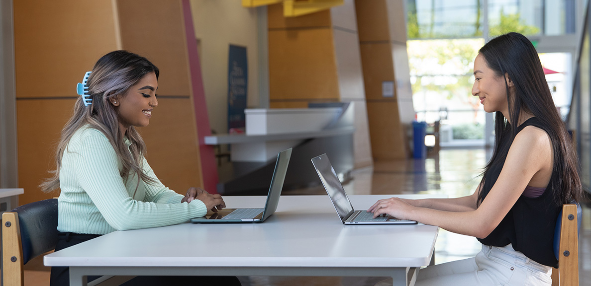 Two female students sitting at a table in the CORE