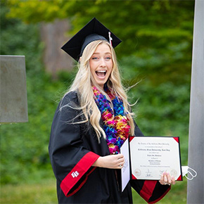 student smiling with certificate grad