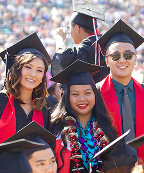 Students pose at graduation in cap and gown