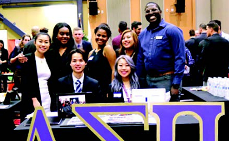 Group of Delta Sigma Pi students pose at event
