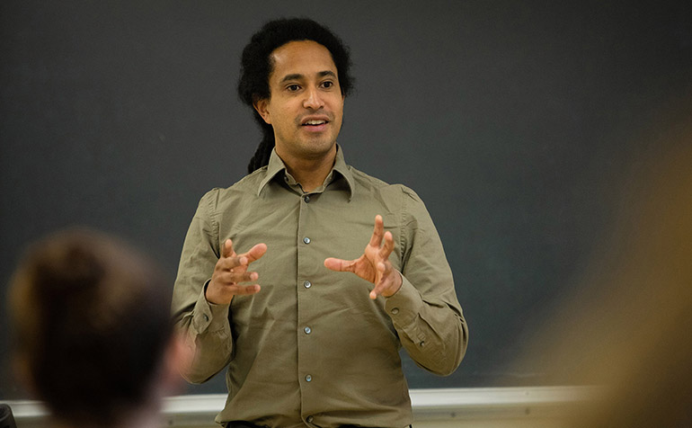 Male teacher stands in front of a classroom