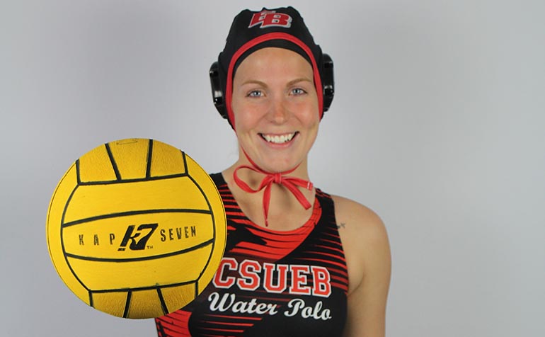 Player in cap holds out water polo ball