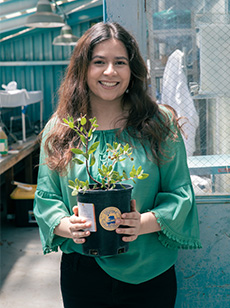 Student holding potted plant