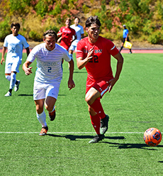 Two soccer players compete for ball