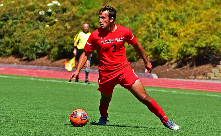 Male soccer player dribbles ball