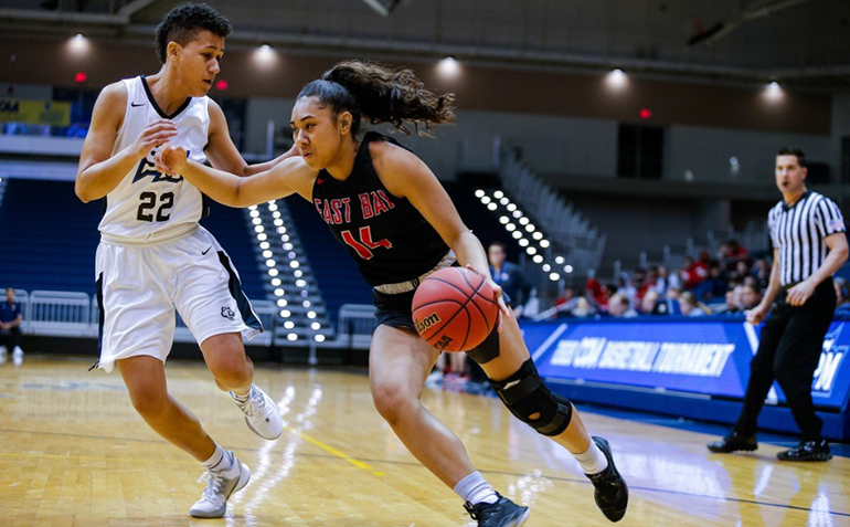 Two female basketball players compete