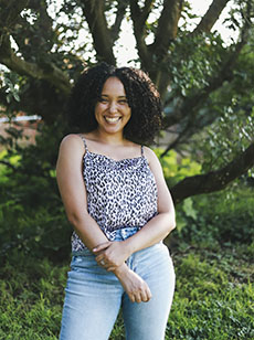 Woman stands in front of tree