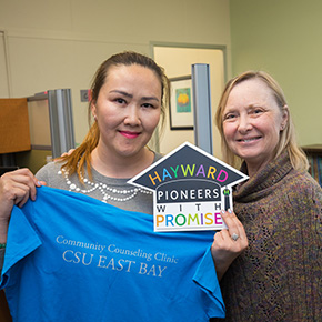 two women standing with sign 