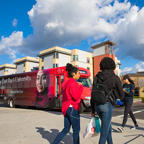 students walking across campus housing 
