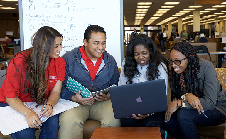 Four students work on project in the library