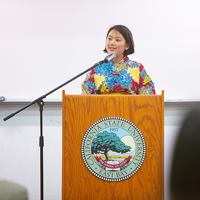  A woman speaks into a microphone at a podium