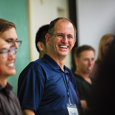  A man in a blue polo shirt and glasses smiles