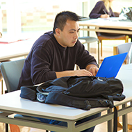 Male student works at laptop