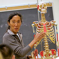 Professor stands with skeleton
