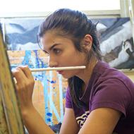 Student paints on an easel