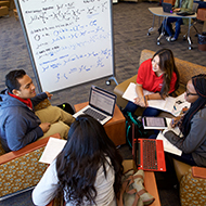 Four students collaborate on project in the library 
