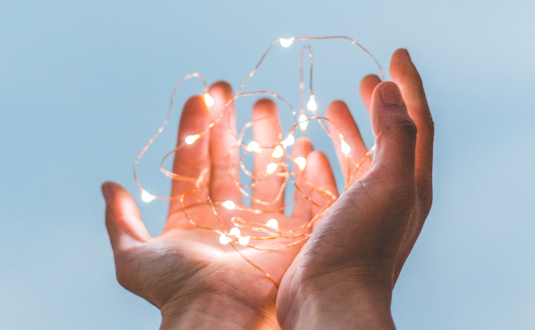 Two hands holding up a light