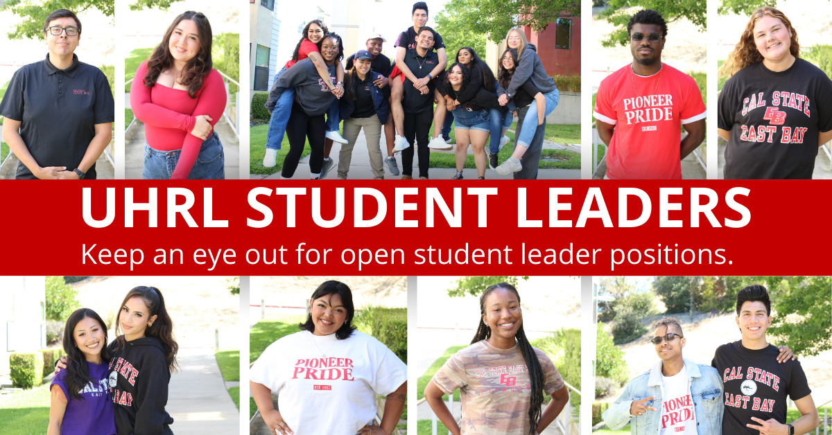 Picture of 7 student leaders wearing Cal State East Bay apparel in front of a residence hall. Two are in front sitting on the grass, two are swatting behind them and the last 3 are standing in the back