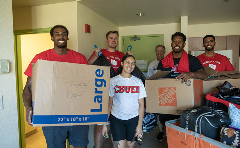 Student posing with moving boxes