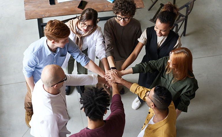 Students standing in a circle with their hands together