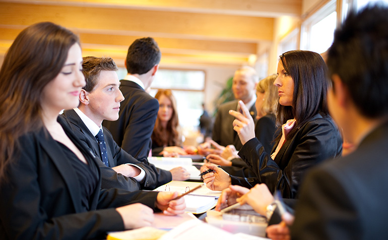 Professionally-dressed students sitting at a table