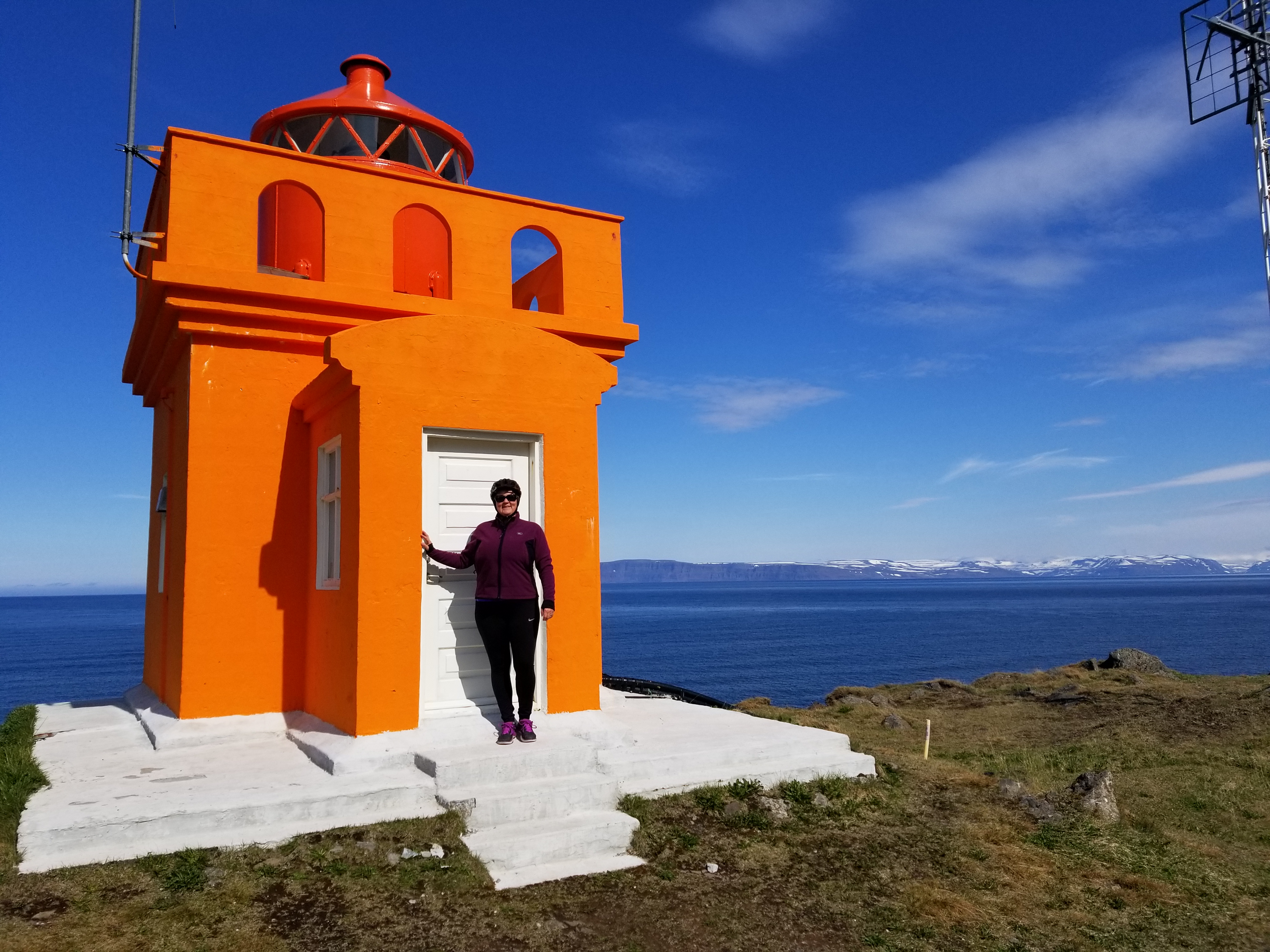 women in front of orange lighthouse