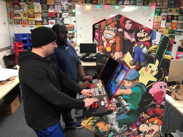 Two members of the development team trying out the Arcade Machine with some classic co-op games