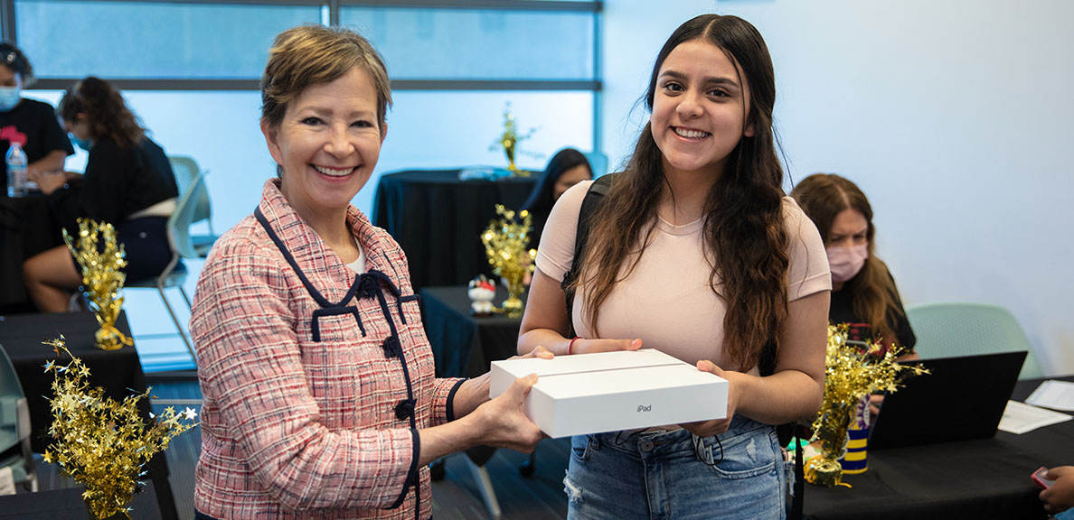 President Cathy Sandeen meets a student receiving an iPad