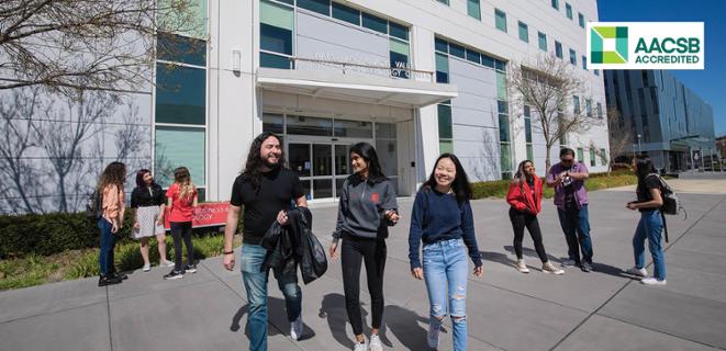 students walking in front of business and technology building