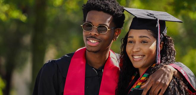 Two graduates pose for photo