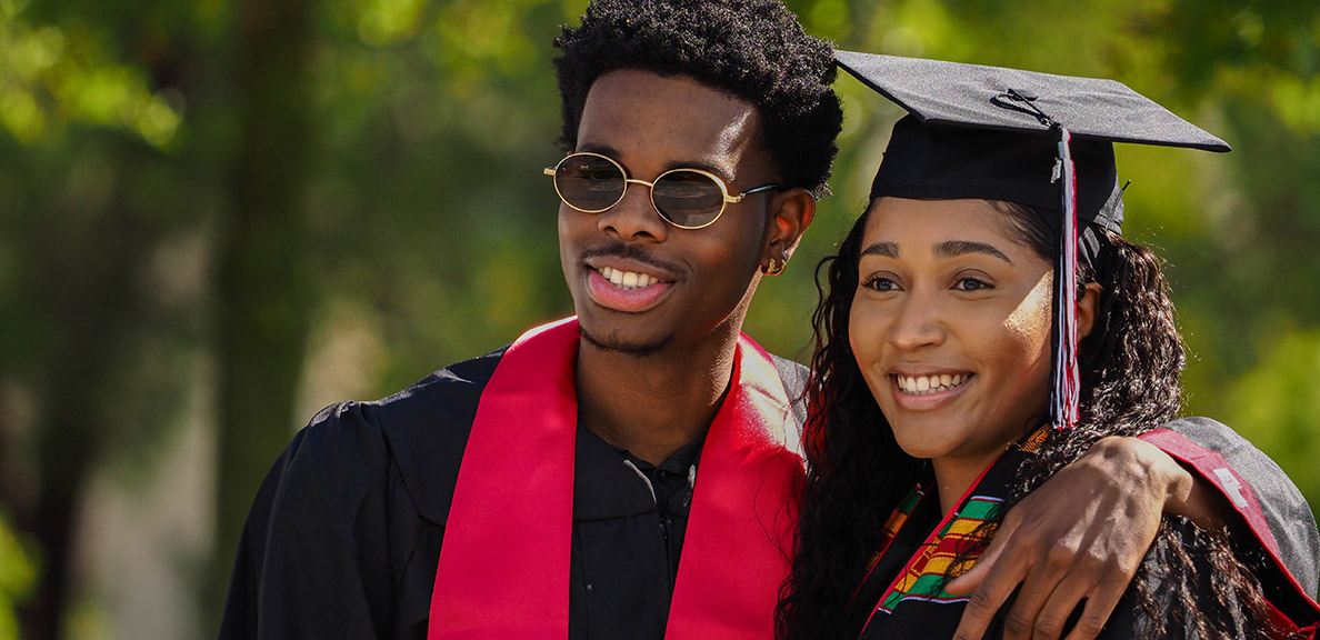 Two graduates pose for photo