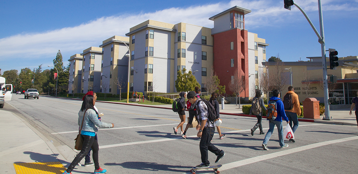 Students walking across intersection in front of student housing