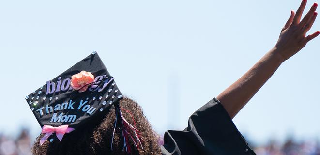 Graduate in cap waves hand