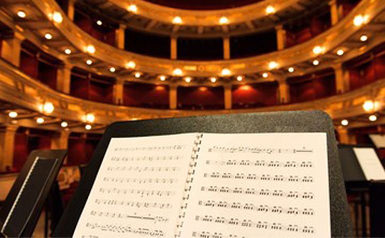 Support Music Students Performing at Carnegie Hall (image description: music stand at a concert hall)