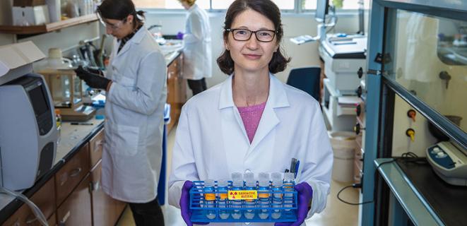 Professor in white coat holds experiment