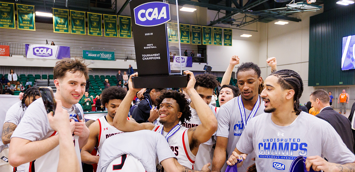 Men's Basketball team members holding up their CCAA trophy