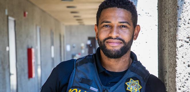 Michael Elder leans against post wearing police uniform