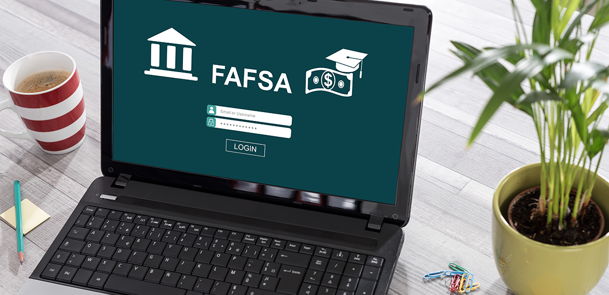 Laptop on a desk showing FAFSA login screen