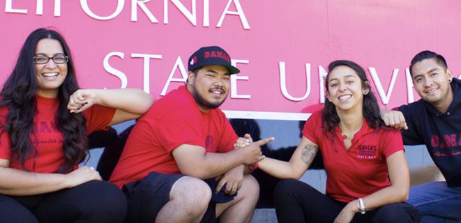 Students stand in front of CSUEB sign