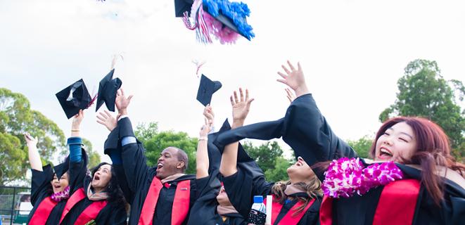 Students throw grad caps in the air