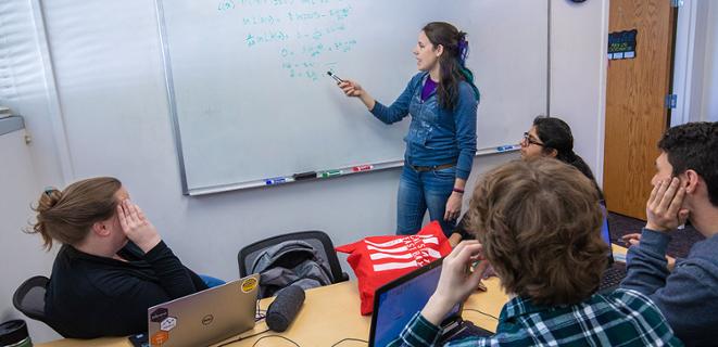 Instructor teaching math points to white board