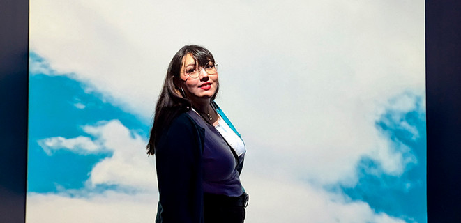 Jazmin Garcia standing in front of an illuminated sky background screen