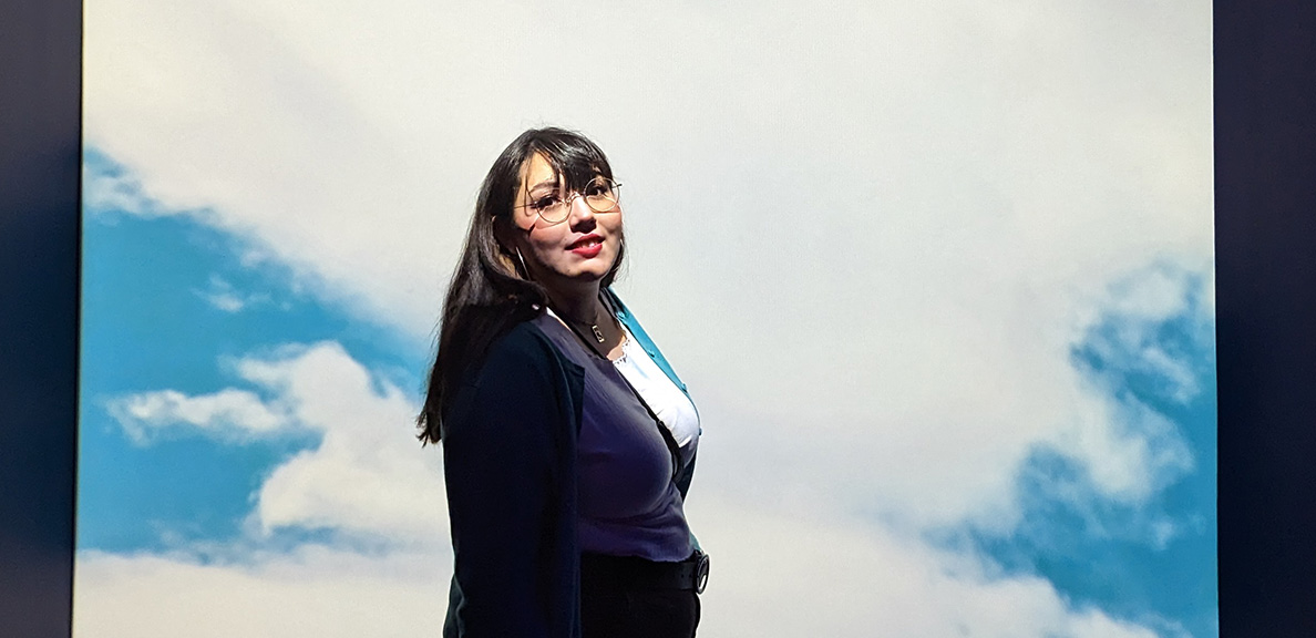 Jazmin Garcia standing in front of an illuminated sky background screen