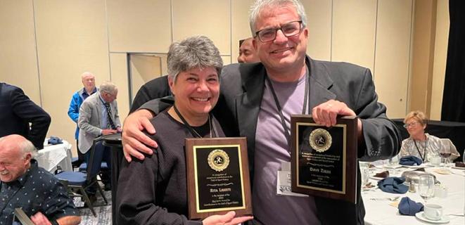 Rita Liberti and Dave Zirin holding up their awards