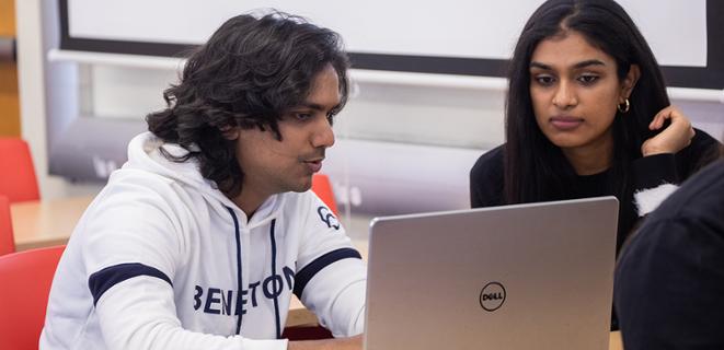 Two students looking at laptop together