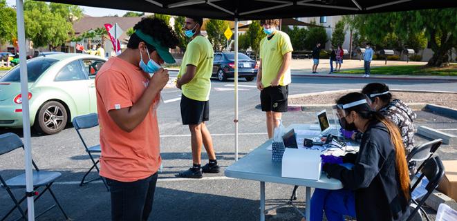 Student in mask waits at testing booth