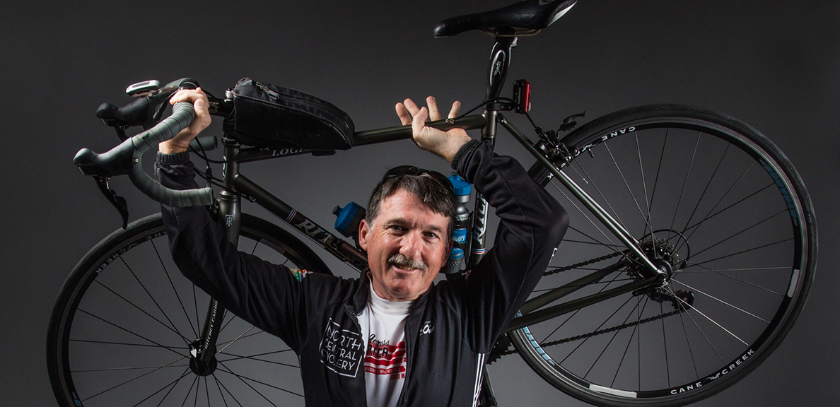 Paul Carpenter holds a bike over his head