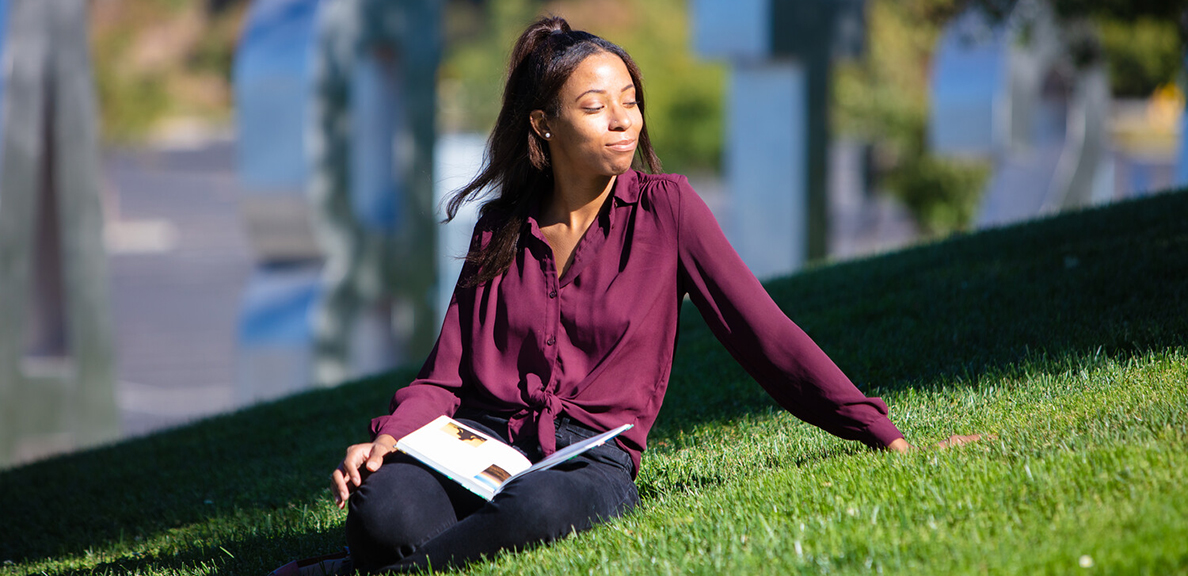 Ester Fultz sits on grassy hill