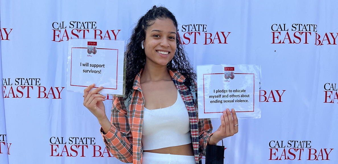 Female student holding signs to pledge support of those who have been sexually assaulted 