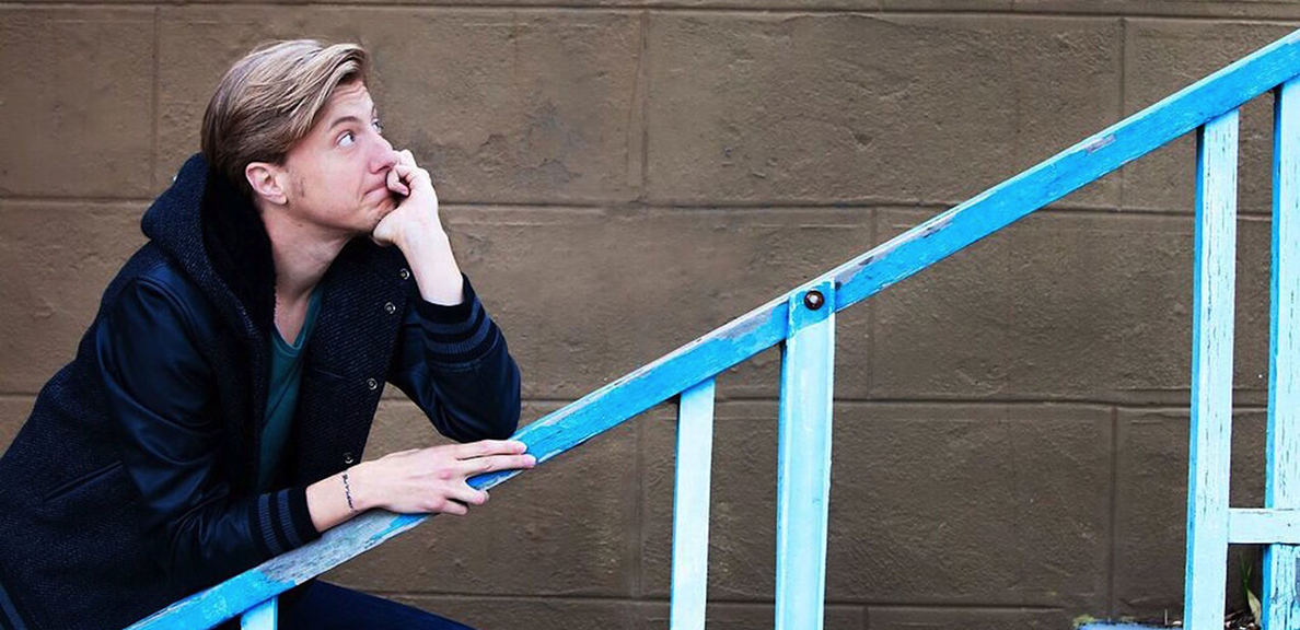 Scott Turner Schofield poses on a blue stairway